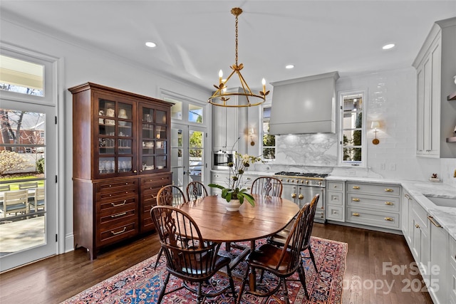 dining room with a notable chandelier, dark wood-style flooring, and recessed lighting