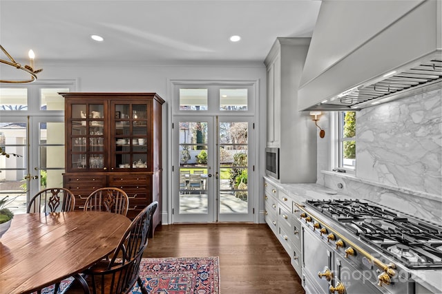 kitchen featuring dark wood-style floors, french doors, stainless steel appliances, tasteful backsplash, and custom range hood