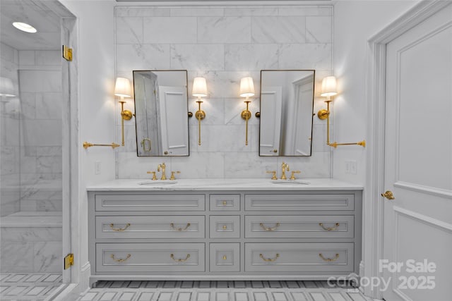 bathroom with double vanity, a sink, a marble finish shower, and decorative backsplash