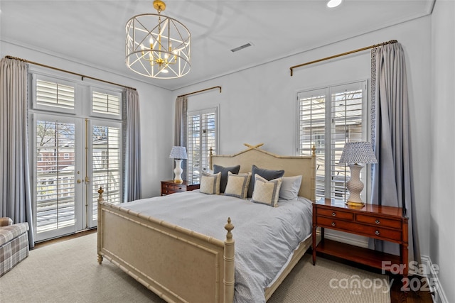 bedroom with access to exterior, a chandelier, and visible vents