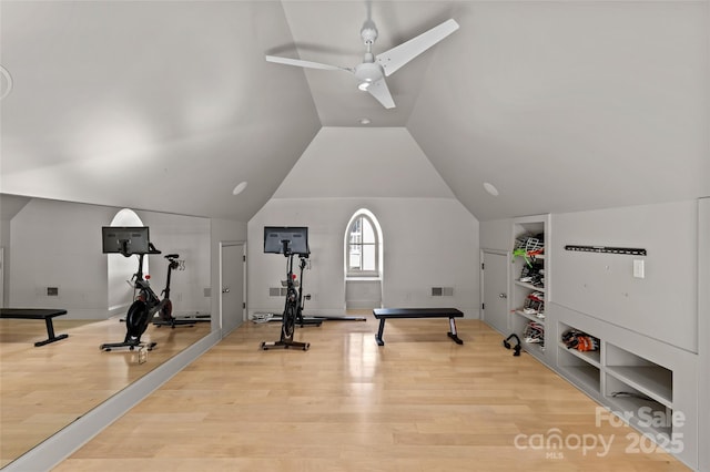 workout area featuring vaulted ceiling, ceiling fan, wood finished floors, and visible vents