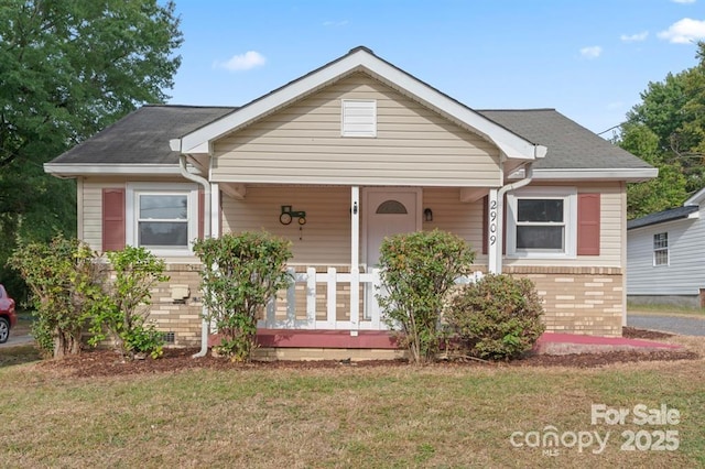 bungalow featuring a front lawn, a porch, and brick siding