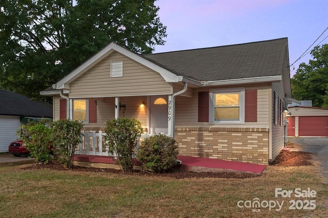 bungalow-style house featuring a porch, a front yard, brick siding, and a shingled roof