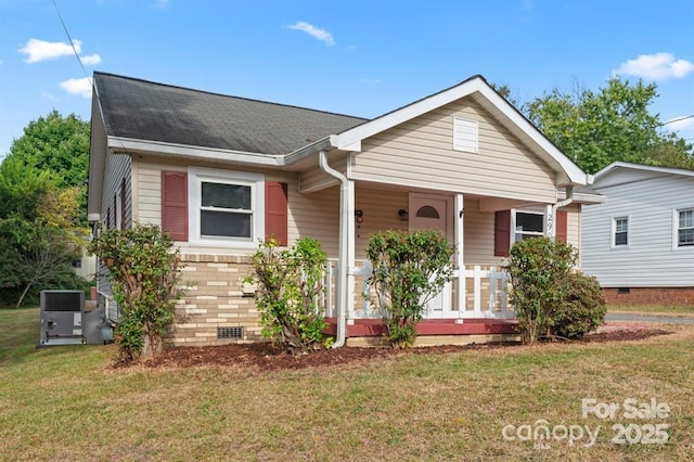 bungalow-style home with central AC unit, covered porch, a shingled roof, crawl space, and a front yard