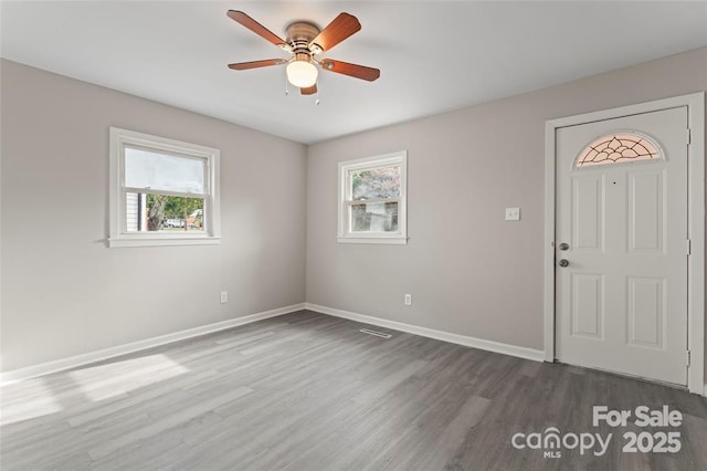 entrance foyer featuring a ceiling fan, dark wood finished floors, plenty of natural light, and baseboards