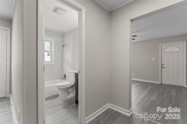 interior space featuring shower / washtub combination, visible vents, baseboards, and wood finished floors