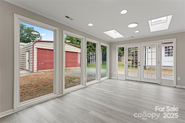 unfurnished sunroom with a skylight, visible vents, and french doors