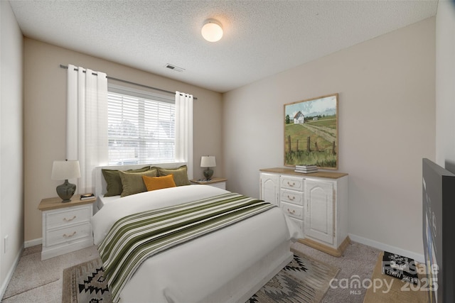 bedroom featuring visible vents, light colored carpet, and baseboards