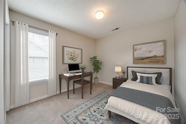 bedroom featuring baseboards, visible vents, carpet floors, and a textured ceiling