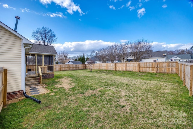 view of yard featuring a fenced backyard and a sunroom