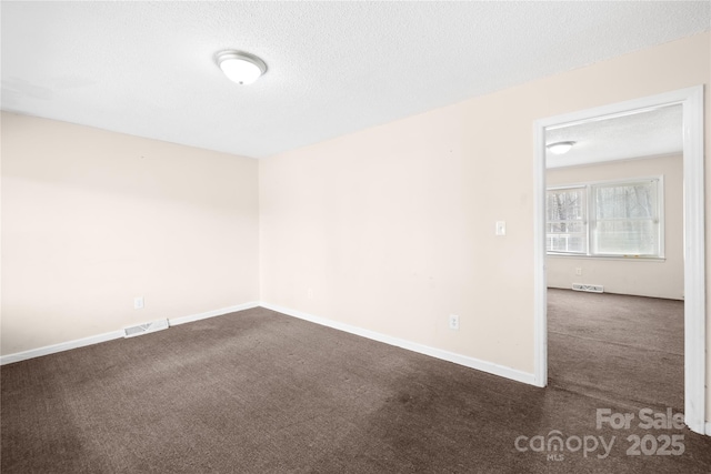 unfurnished room with baseboards, visible vents, a textured ceiling, and carpet