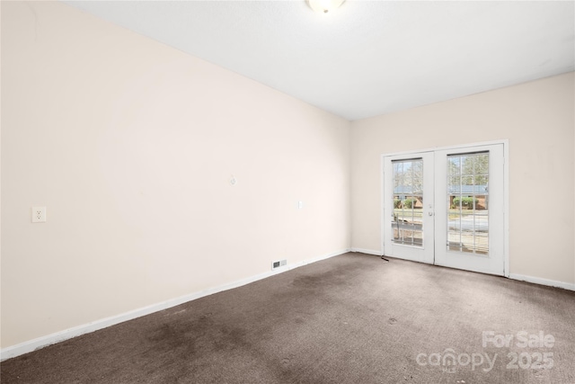 carpeted spare room featuring visible vents and baseboards