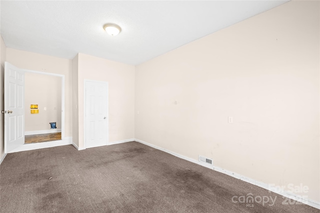 carpeted empty room with visible vents and baseboards