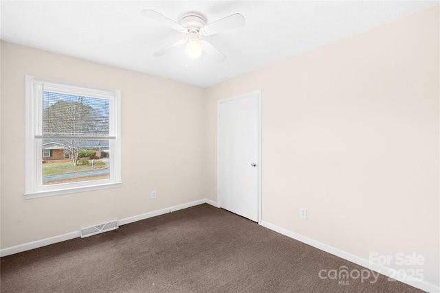 unfurnished room featuring a ceiling fan, baseboards, visible vents, and dark carpet