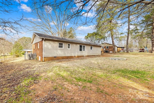 rear view of house featuring a lawn and crawl space