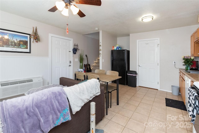 interior space with a ceiling fan, wainscoting, a wall mounted air conditioner, and light tile patterned flooring