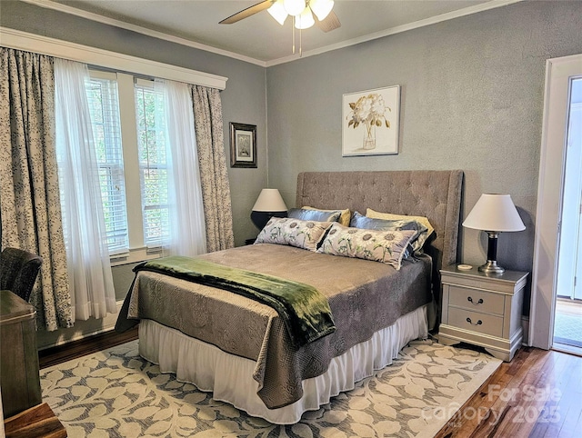 bedroom with ornamental molding, a ceiling fan, and light wood-style floors