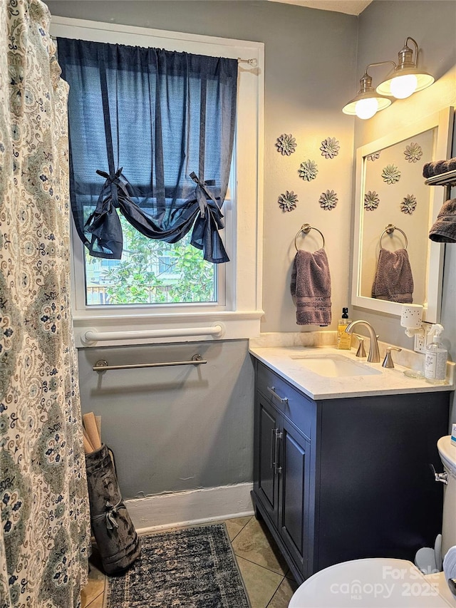 bathroom with vanity, tile patterned flooring, toilet, and baseboards