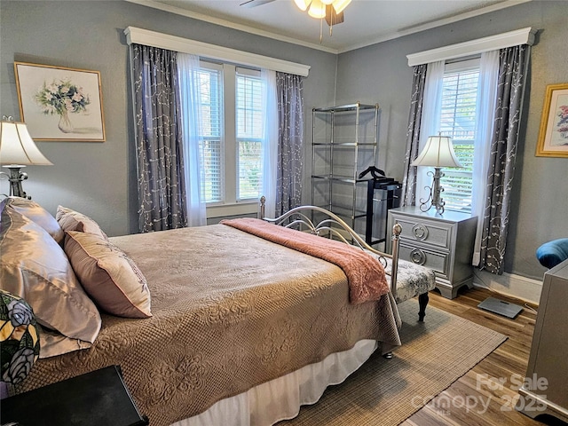 bedroom featuring baseboards, ornamental molding, and wood finished floors