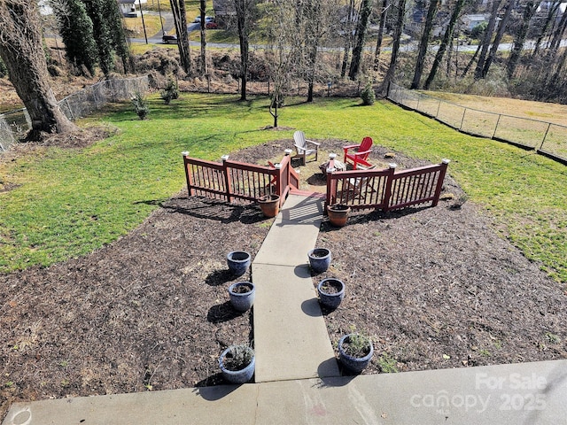 view of yard with a fire pit and fence