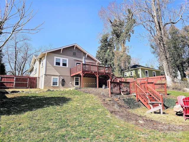 back of house featuring a lawn, a wooden deck, and fence