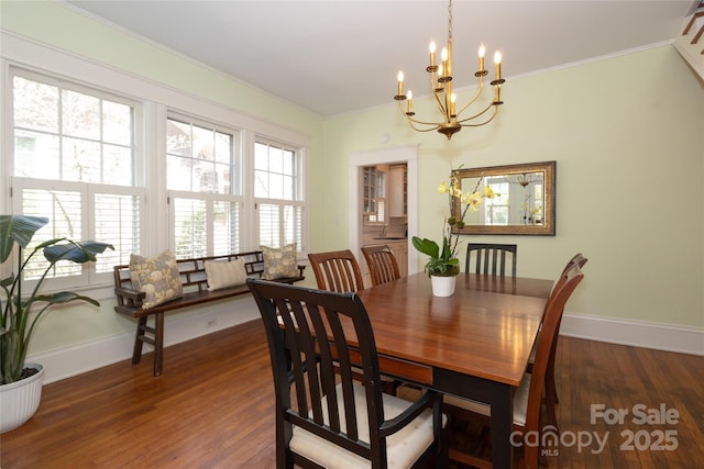 dining room featuring an inviting chandelier, crown molding, and wood finished floors