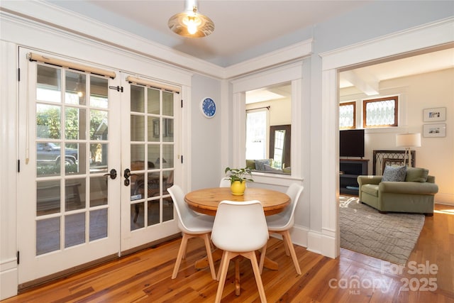 dining area featuring baseboards, ornamental molding, wood finished floors, and french doors