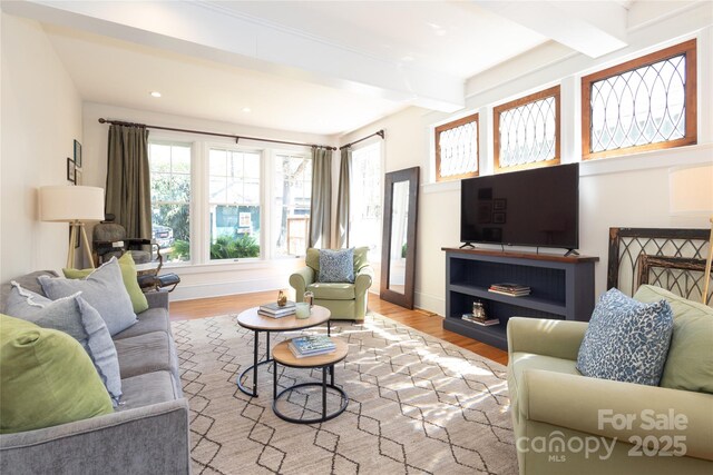 living room with baseboards, wood finished floors, recessed lighting, and beam ceiling