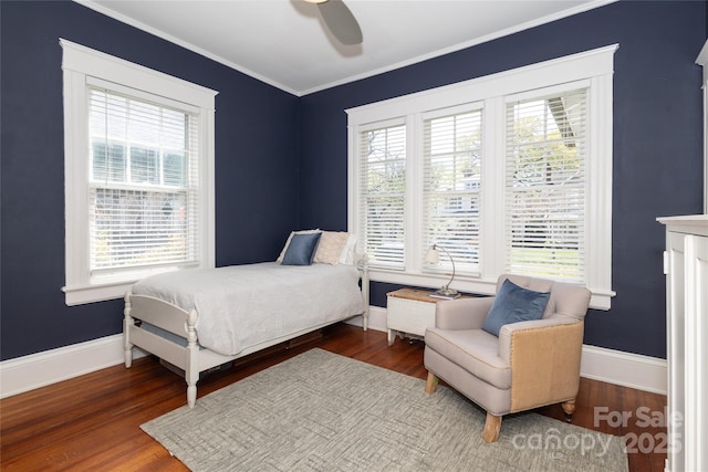 bedroom featuring wood finished floors and multiple windows