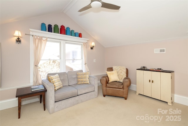 living area featuring light carpet, lofted ceiling, baseboards, visible vents, and ceiling fan