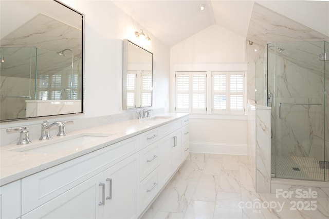 bathroom with marble finish floor, a sink, vaulted ceiling, and a healthy amount of sunlight