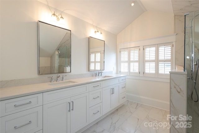 bathroom with a marble finish shower, marble finish floor, lofted ceiling, and a sink