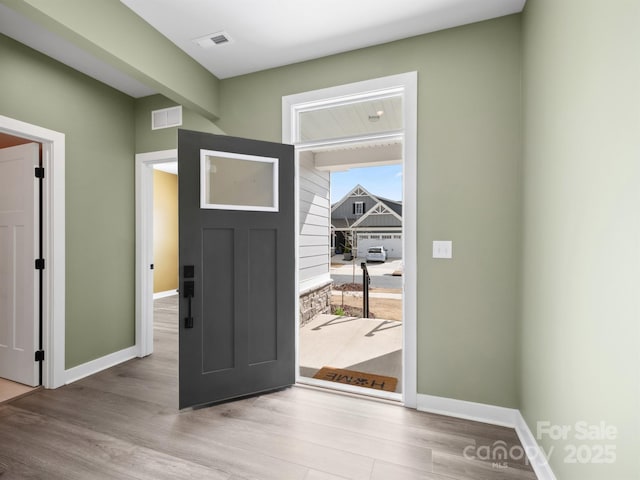 entrance foyer with baseboards, visible vents, and wood finished floors