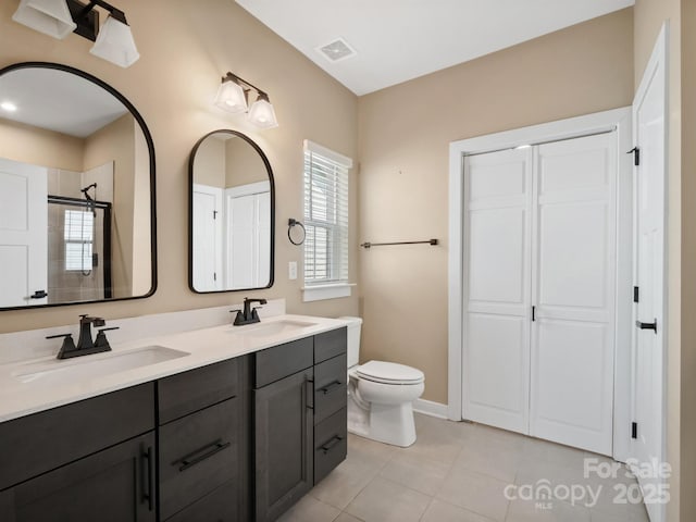 bathroom with visible vents, a sink, toilet, and tiled shower