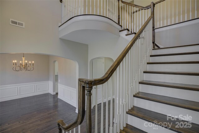 17809 Pawleys Plantation Ln, Charlotte, NC 28278 - stairs with visible vents, a towering ceiling, wood finished floors, arched walkways, and a notable chandelier