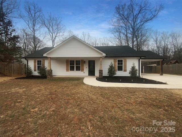 single story home featuring covered porch, a front yard, fence, a carport, and driveway