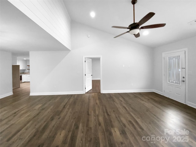 unfurnished living room with lofted ceiling, dark wood finished floors, a ceiling fan, and baseboards