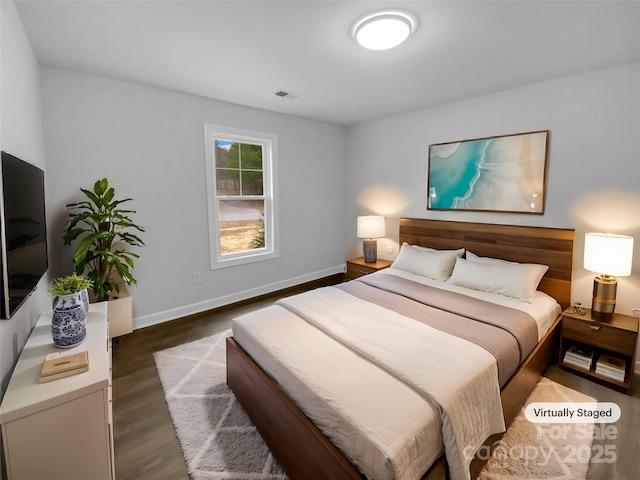 bedroom featuring visible vents, baseboards, and wood finished floors