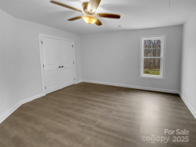 spare room with ceiling fan, baseboards, and wood finished floors