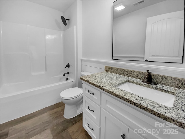 full bathroom with bathtub / shower combination, toilet, wood finished floors, vanity, and visible vents