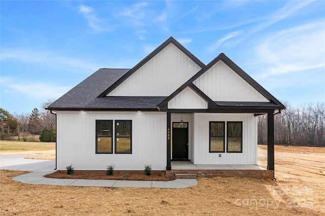 modern farmhouse style home with covered porch and a shingled roof