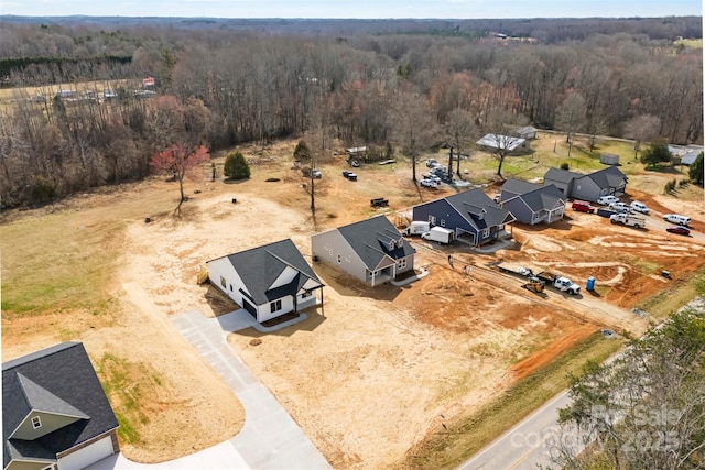 bird's eye view with a wooded view