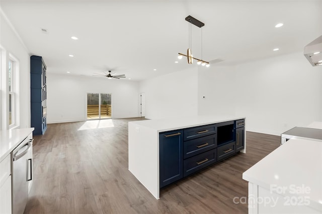 kitchen with dark wood finished floors, blue cabinetry, recessed lighting, light countertops, and stainless steel dishwasher