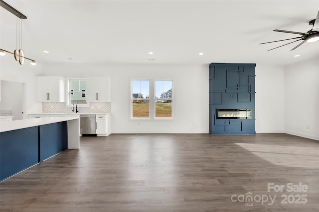 unfurnished living room featuring baseboards, dark wood-style flooring, a ceiling fan, and recessed lighting