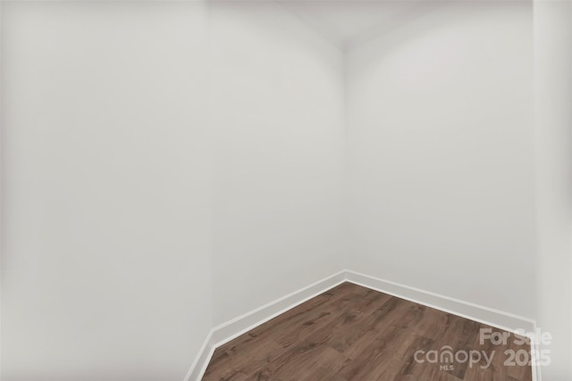 laundry area featuring dark wood-type flooring and baseboards