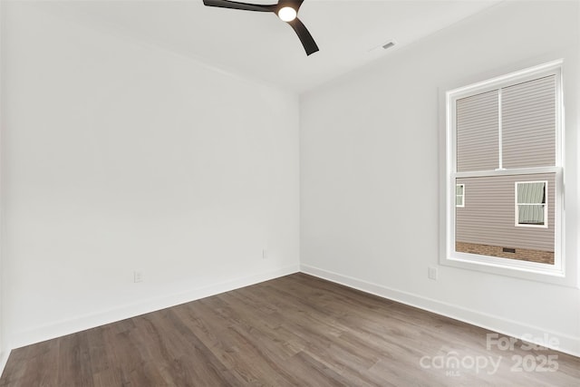 unfurnished room with a ceiling fan, dark wood-style flooring, visible vents, and baseboards