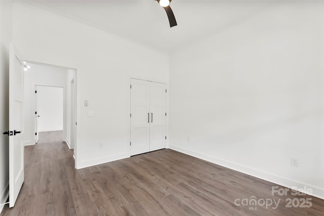 unfurnished bedroom featuring a closet, baseboards, and wood finished floors