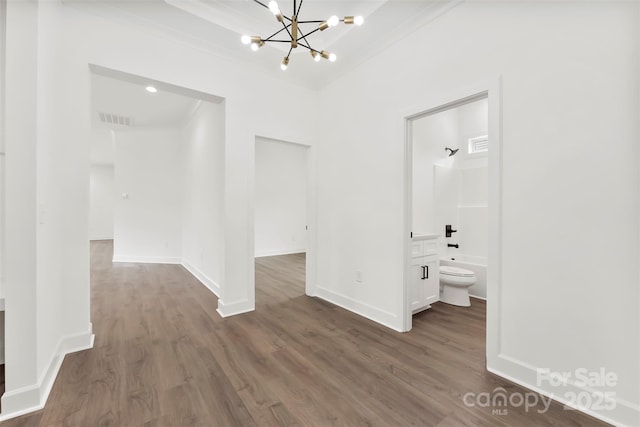 interior space with baseboards, visible vents, dark wood-style flooring, crown molding, and a notable chandelier