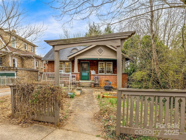 view of front of property featuring fence and brick siding