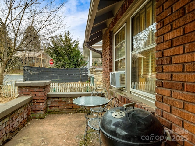 view of patio with grilling area, fence, and cooling unit